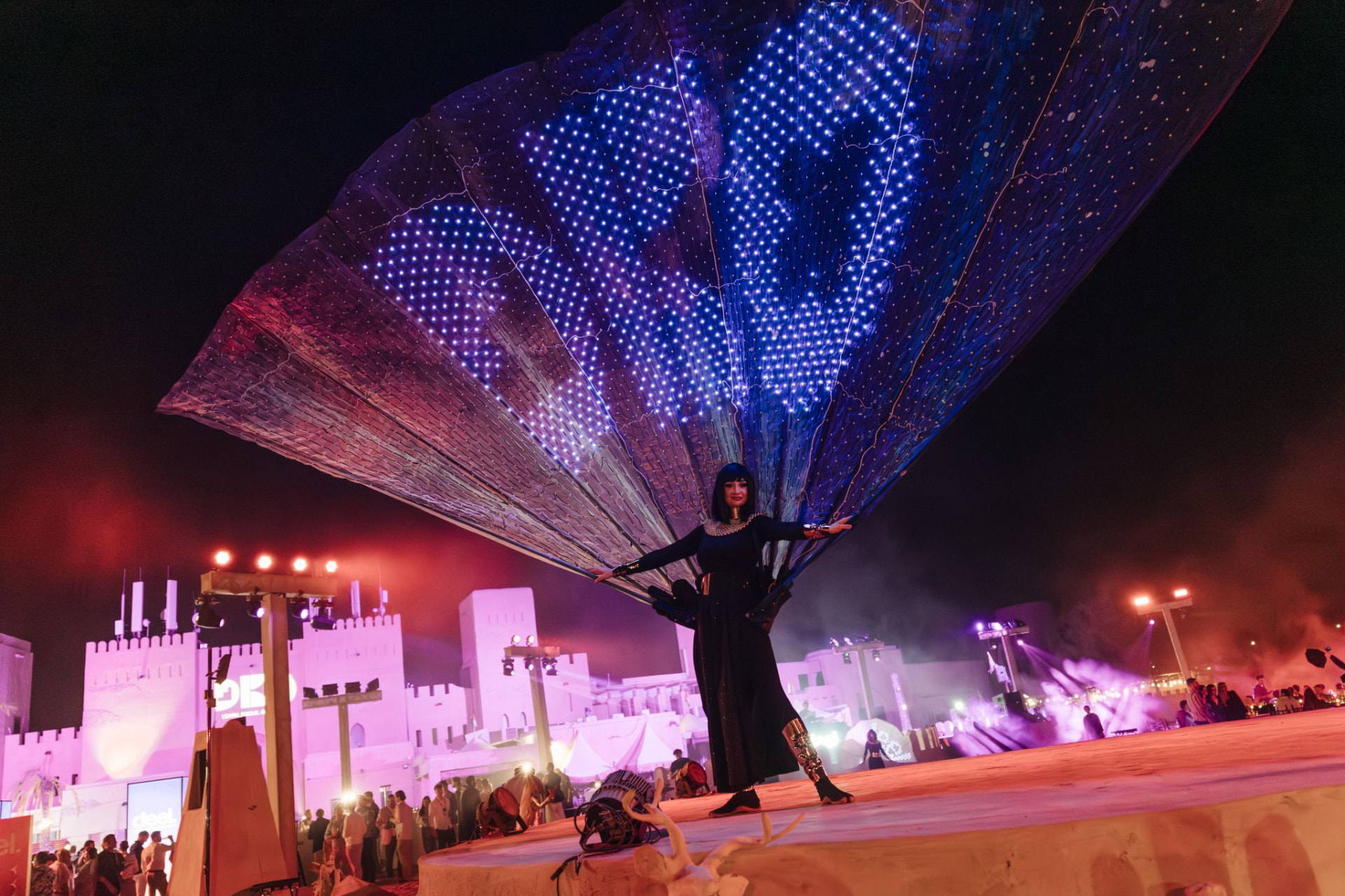 A performer in an illuminated LED costume bringing energy to the stage during an evening entertainment moment