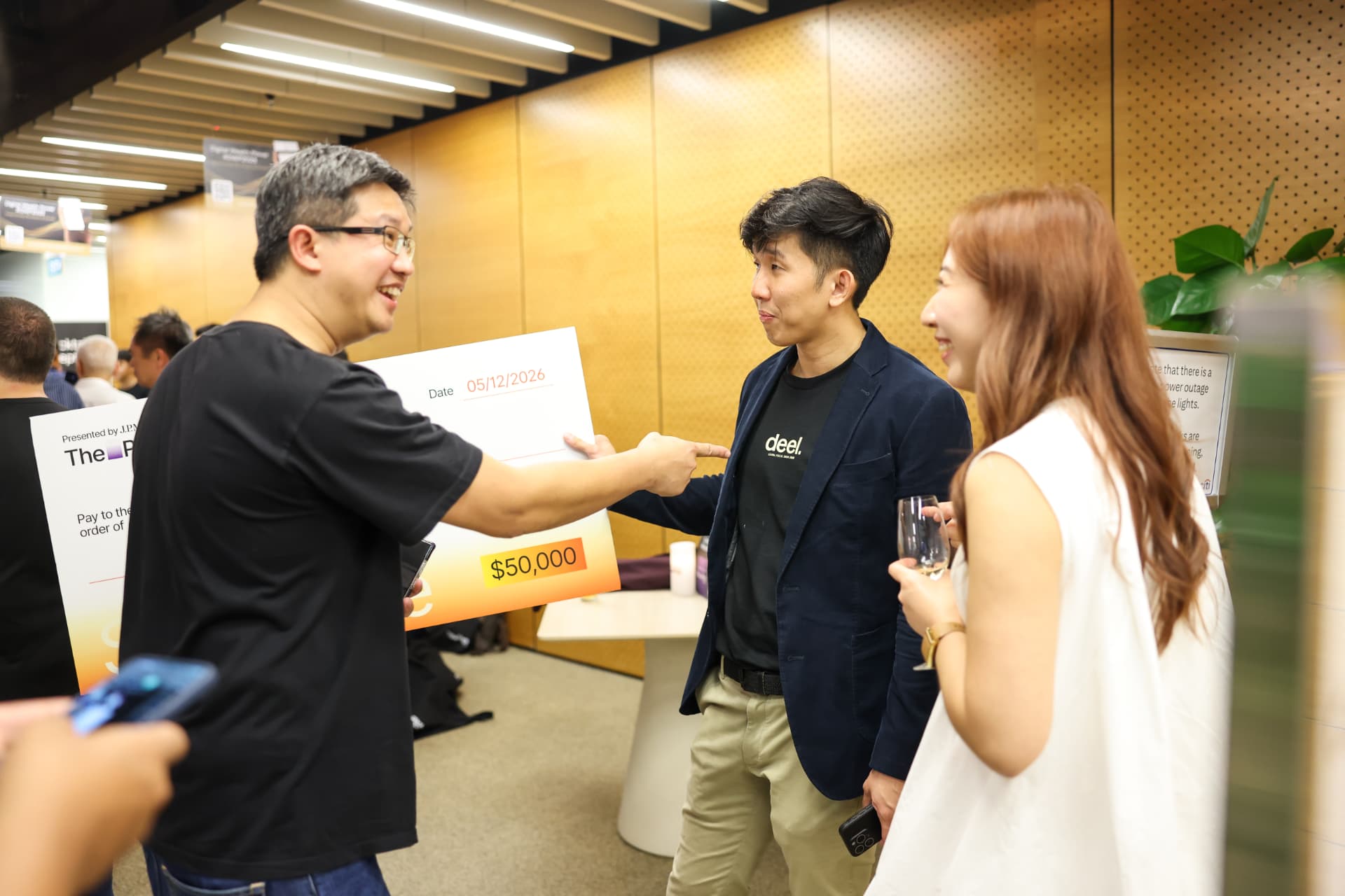 Guests in conversation beside the winner's cheque in Singapore