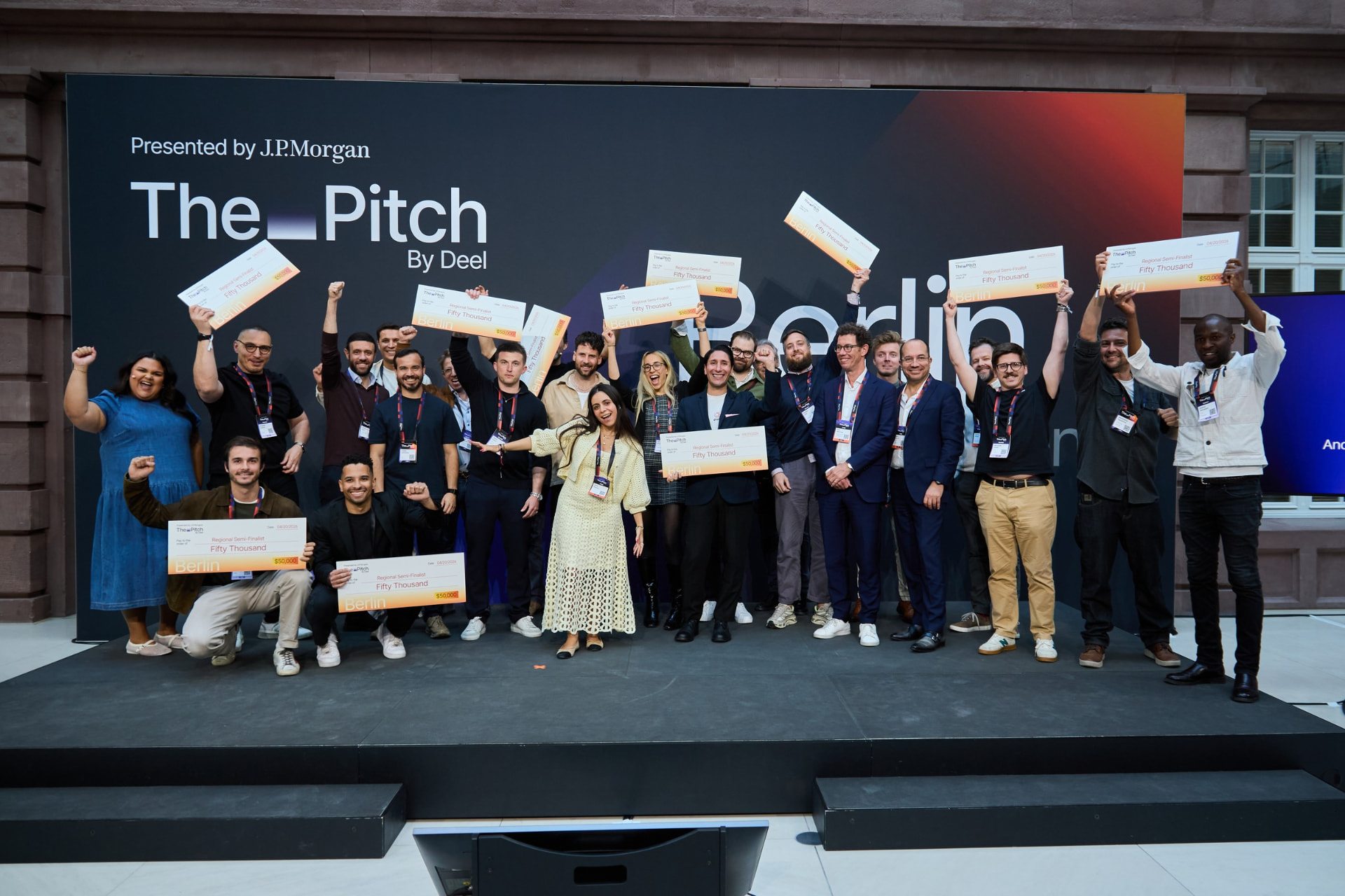 Regional semi-finalists celebrating on stage at the close of the Berlin event