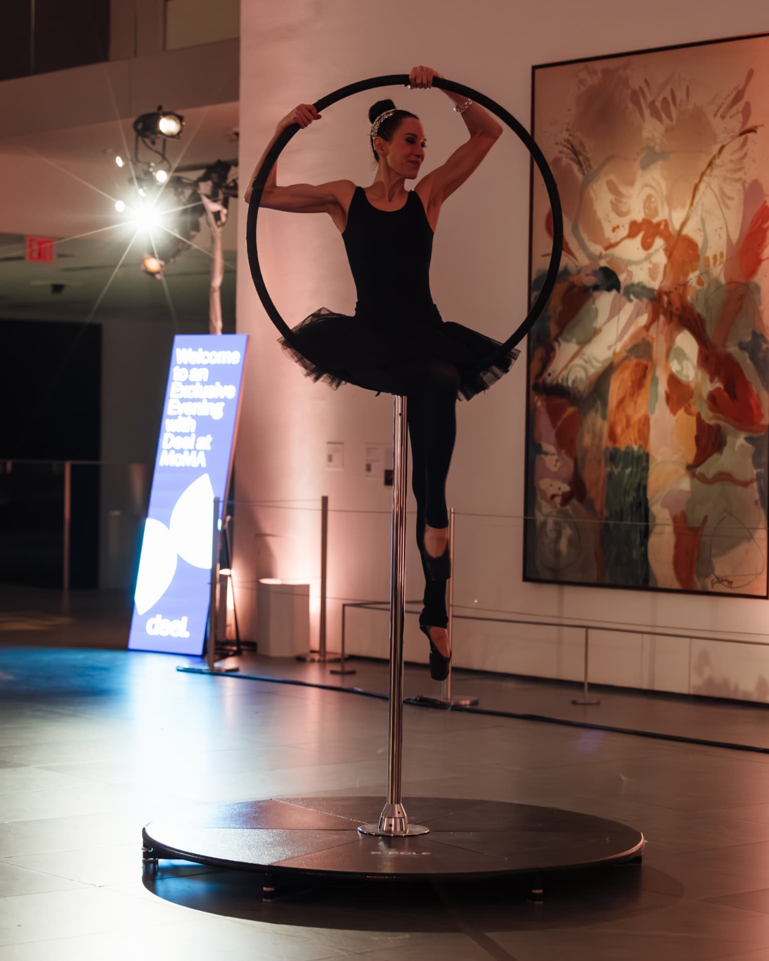 Aerial ballerina performing on a hoop in the gallery