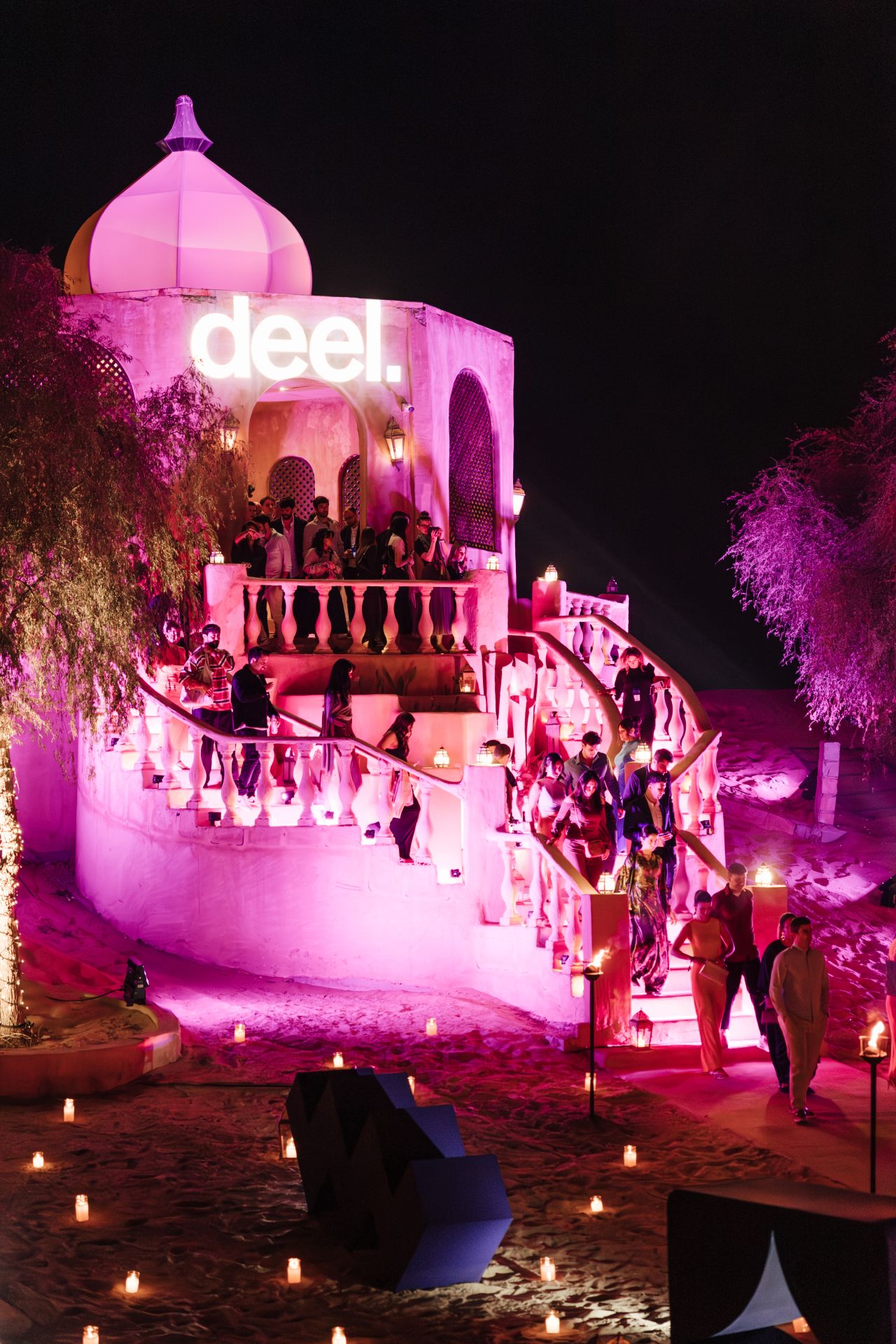 Guests descending the illuminated deel staircase into the desert celebration