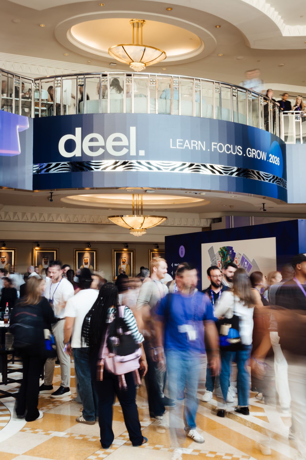 Attendees moving through the venue atrium beneath Learn. Focus. Grow. branding