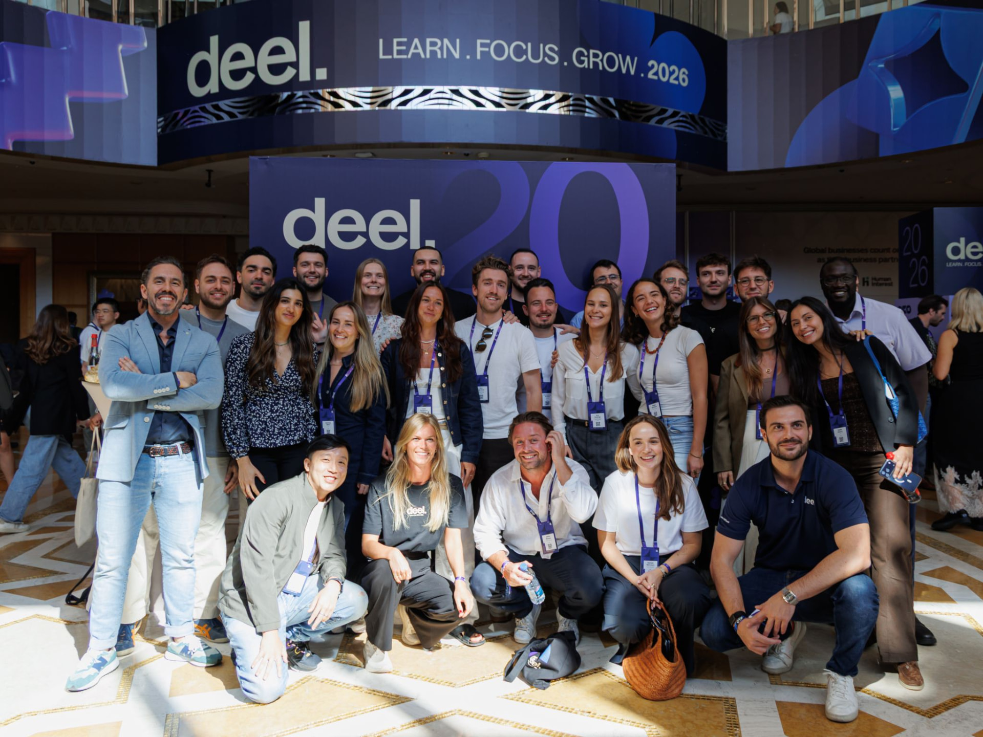 A large group of colleagues gathered together for a photo in the venue atrium