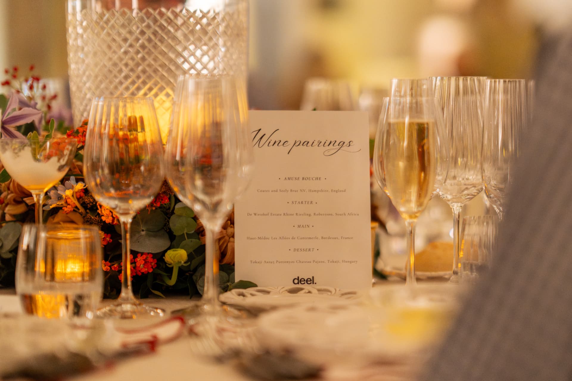 Wine pairing menu card among crystal glassware and florals on the dinner table